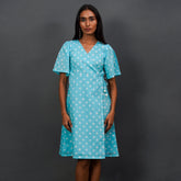 Discover Ambr by The Sootee — a breezy sky blue Bandhani cotton wrap dress with a flattering V-neckline, short sleeves, and side pockets. Hand-tied and dyed using traditional techniques, this sustainable slow-fashion piece blends artisanal craft with everyday comfort and uniqueness.