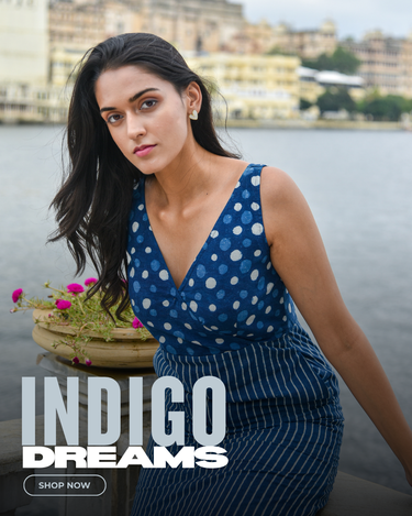 Woman in a blue polka dot dress by a lake with 'Indigo Dreams' text overlay.