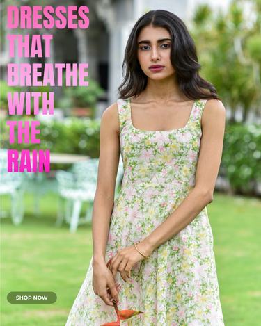 Woman wearing a floral dress with text 'Dresses that breathe with the rain' and 'Shop Now' on a blurred outdoor background.