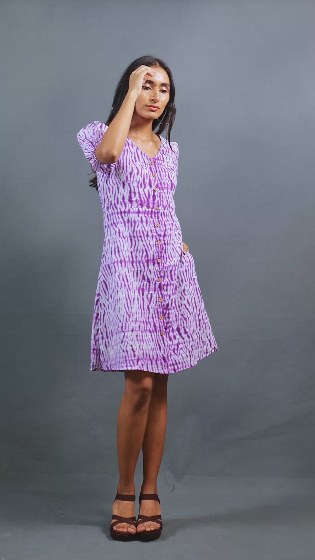 Meet Jamuntini by The Sootee — a purple Shibori cotton dress with a V-neckline, puff sleeves, wooden buttons, and side pockets. Hand-dyed and fully lined for comfort, this sustainable slow-fashion piece combines artisanal craft with playful vintage elegance.